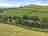 Dartmoor Halfway Inn: View of the site from hill, plenty of open green space on site 