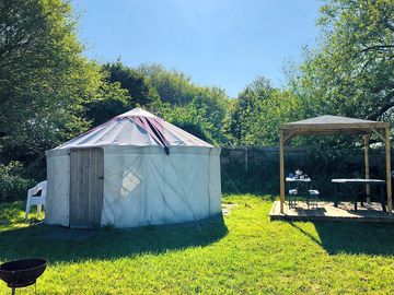 The outside of the yurt and the wooden gazebo for use to cook under if raining
