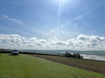 A motorhome pitched up enjoying a quiet morning overlooking the estuary