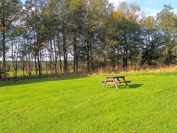 Non-electric grass pitch, showing one of the picnic benches available around the site