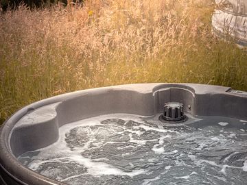 The hot tub is tucked away behind the yurt so completely private