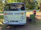 Our old vw camper on the main field with a chap sat on a chair beside it