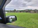 View towards driveway from field - toilets on the left, playground to the right.