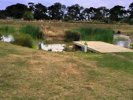 Pond to the rear of the site with benches