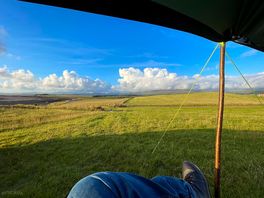 View from tent towards hills with boot and high-tech tarp pole.