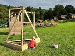 Play swing set and football goal looking back on the pods.