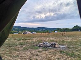 Looking out tent door with complimentary campfire