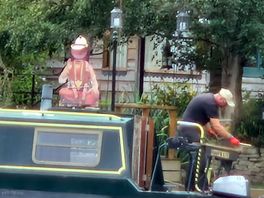 A statue of an old cowboy on a barge.