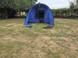 6 man tent part way through putting up. the wooden markers give idea of pitch size.