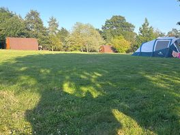 Campsite with view of a tent and a cabin