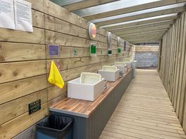 Drinking water and washing up area. with dish washing soap, bowls and drainers.
