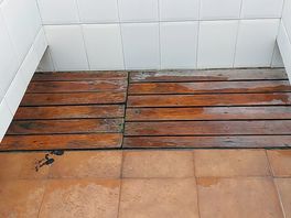 Slimy wood platforms in showers over open drain