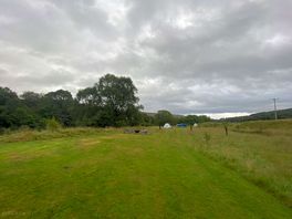 View of the camping pitches running along the side of the riverbank