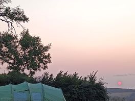 Red sunset over swallow farm barn campsite