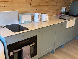 Kitchen with oven, hob, toaster, kettle and dishwasher.