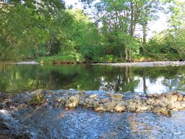 The river runs alongside the campsite