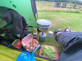Evening meal with view from tent to campsite facilities in the huts.