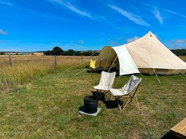 Furnished bell tents come with a outdoor chairs, a picnic bench, fire pit, and first bucket of logs