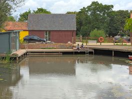 Wild pond with sauna to the side. surrounding buildings are airbnbs/cabins