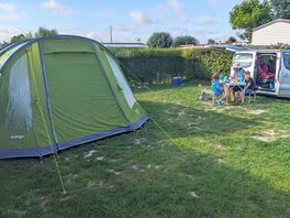 Family camping with tent and car on a nice sized grass pitch at camping les deux plages