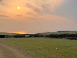 Field with path that leads to the coast path.