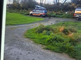 The 2 gravel pitches with electric with 2 campervans clearly set up in them.