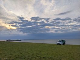 A huge field overlooking the sea. perfect place to unwind after a busy day at craft festival cymru