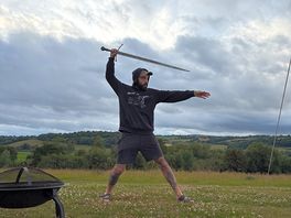 Wielding our freshly forged sword from oldfield forge in front of our tent and the wonderful view