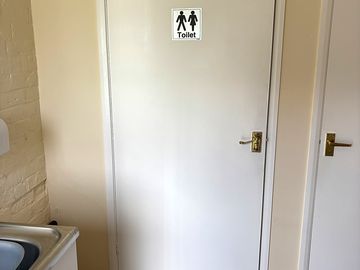 The toilet cubicle, large enough to accommodate a wheelchair user.