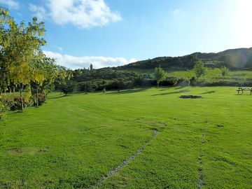A view of the main camping area featuring a firepit and picnic tables