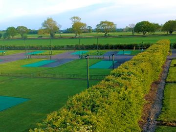 Fully-serviced hardstanding touring pitch with astro-turf awning bay and grass area