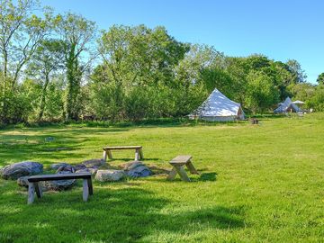 A view up the camping field with the communal firepit in the foreground.