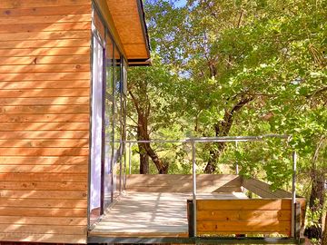 The cabin's balcony overlooking oak trees