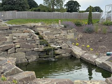 Our beautiful water fall with the water cascading down the rocks surounded by our beautiful gardens.