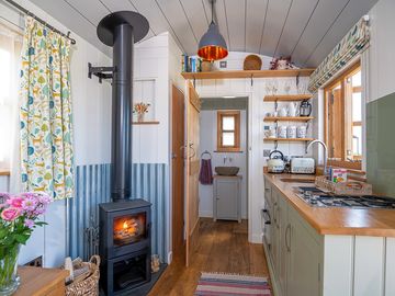 A fully equipped kitchenette complemented by the inviting warmth of a cosy log burner.