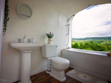 Trailer bathroom with sink, toilet, bath and overhead shower