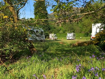 Electric hardstanding pitches are spaced around a central lawn with a circular access road