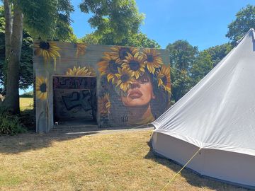 Bell tent next to spraysaints girl with sunflowers