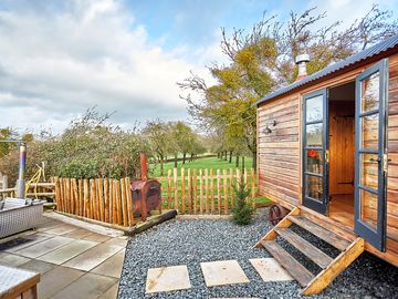 Hut exterior, with pizza oven and hot tub