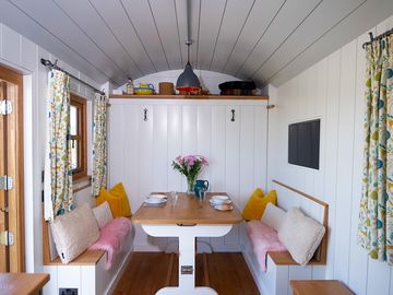 A quality oak dining table for two with a king-size bed that hides behind the wall with a smart tv.