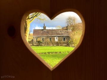 View across the road to meurig cottage from the heart-shaped window in angharad