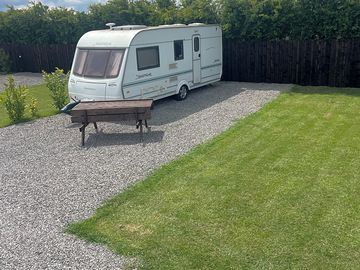 Caravan on a grass and gravel pitch
