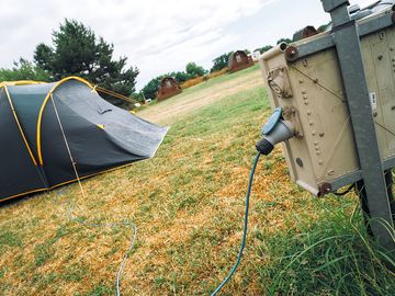 Tent pitched next to electric hook up point on main tent field at the site