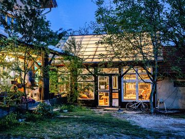 The entrance yard with patio and glass house