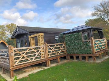 Exterior of the lodge with a hot tub and private garden space