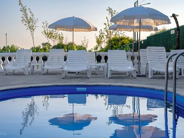 Pool terrace with sun loungers and parasols at camping palić.
