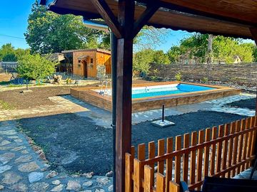 Blick an den ferienzimmern seitlich vorbei auf den pool. im hintergrund das camping-gemeinschaftsbad