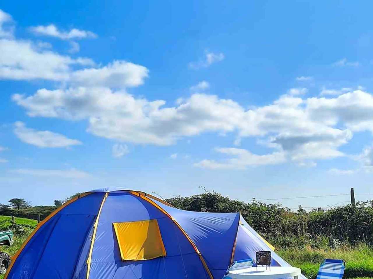 A dome tent with a porch on a peaceful campsite