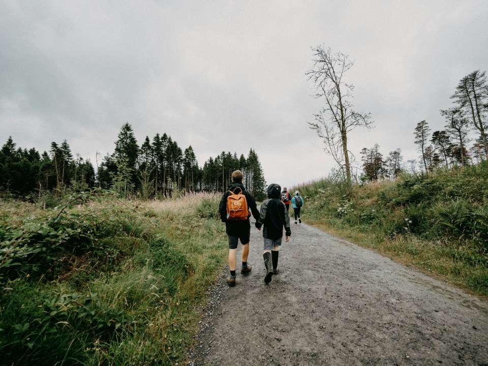 Family of 4 walking down a gravel track