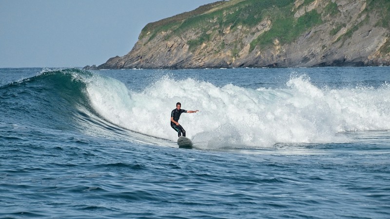 Surfing on the dramatic Pembrokeshire coastline (Miguel A Amutio/Unsplash)